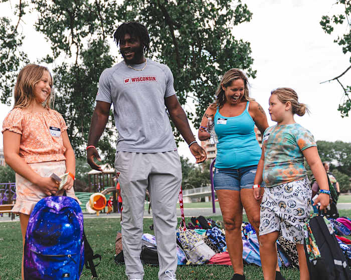 Wisconsin linebacker Jordan Turner giving backpacks to Madison area kids as part of a school supply drive (Credit: Troy Beckman, Team IFA)
